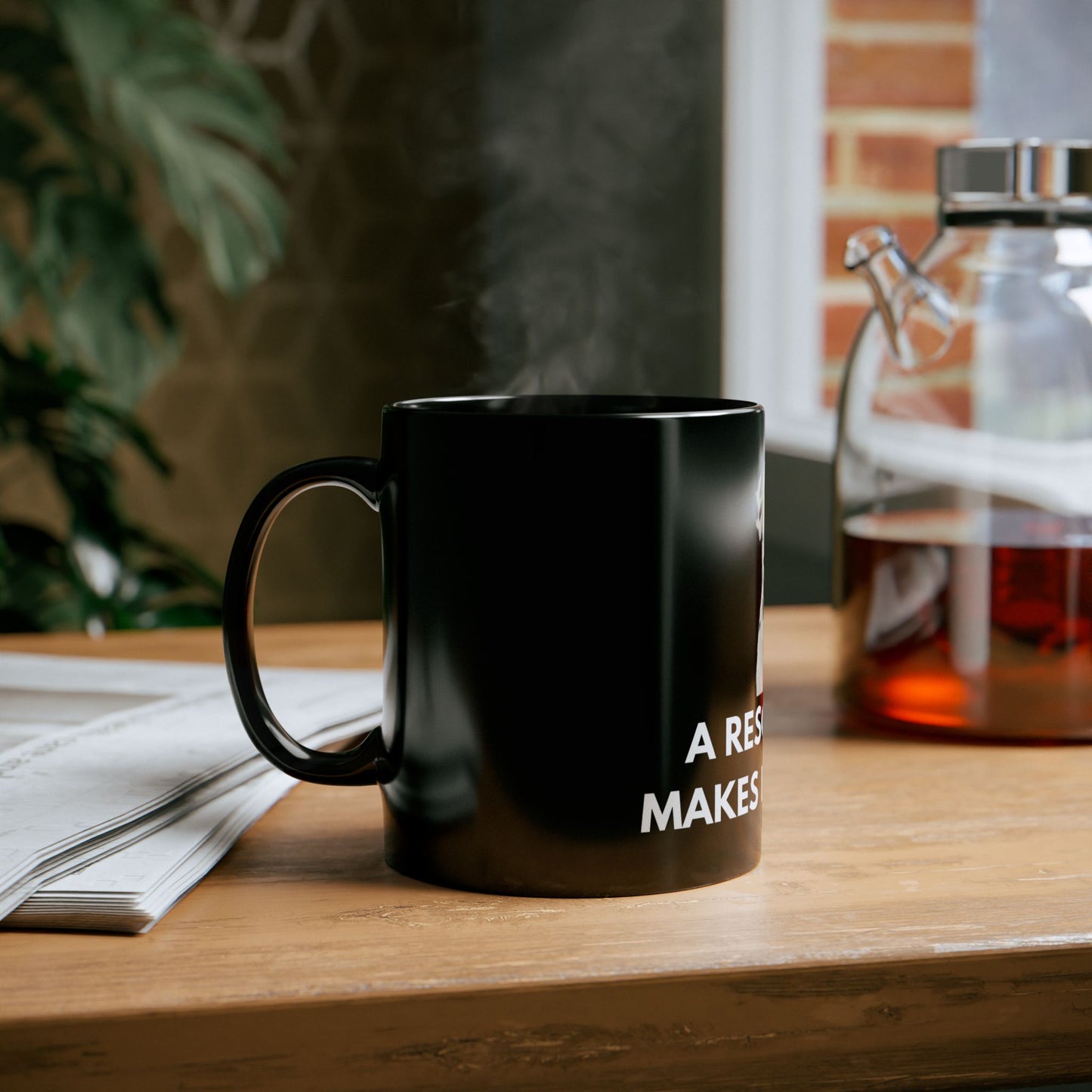 Black mug with text on a wooden table with a blurred background