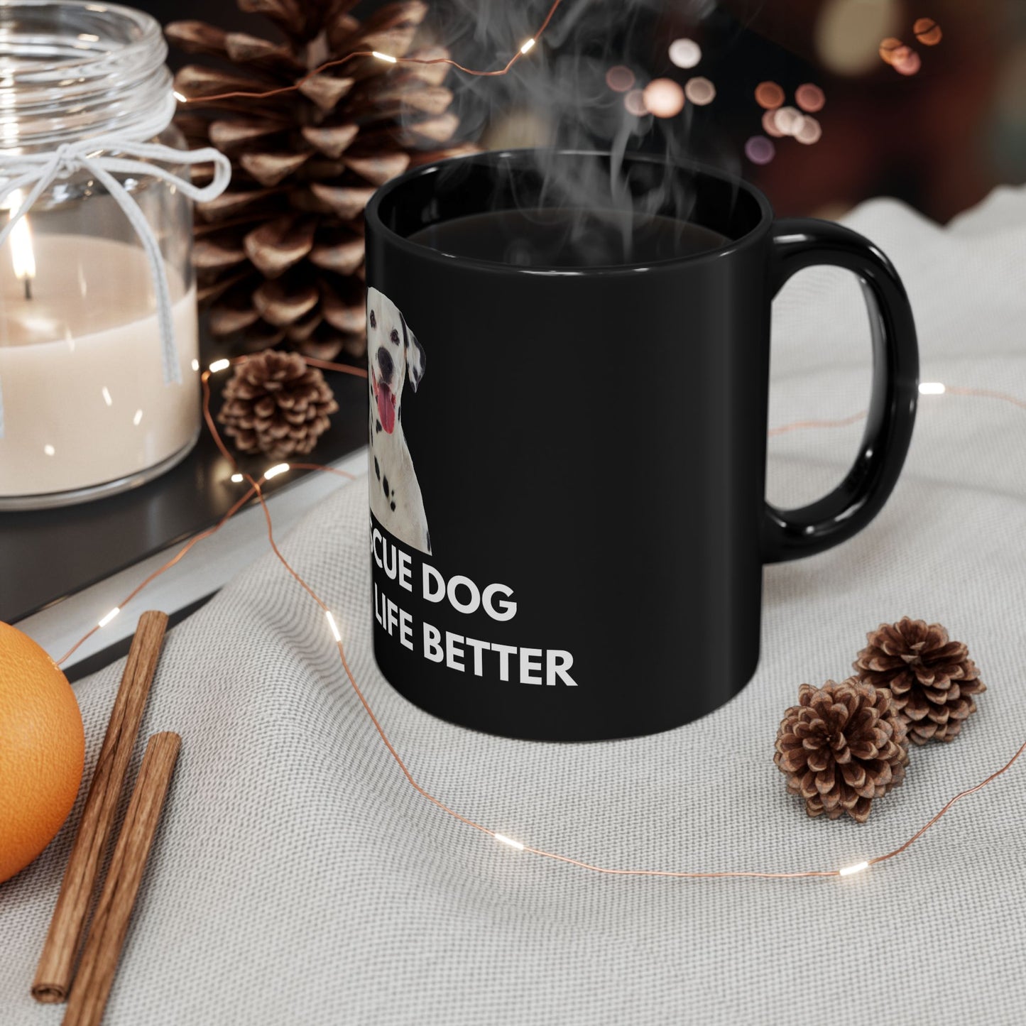 Black mug with a dog graphic and text on a table with decorative items